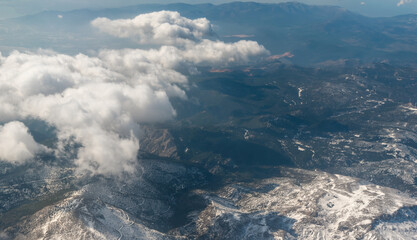 Wall Mural - view from the airplane window to mountains clouds and blue sky