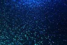 Color Bokeh Glow. Glitter Background. Wet Asphalt Reflection. Defocused Neon Blue Green Light Shiny Sparkles Round Flecks Texture On Dark Black Abstract Overlay.