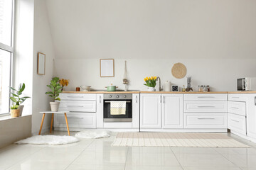 Sticker - Kitchen counters with utensils and beautiful flowers near white wall in room interior