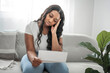 © Louis-Paul Photo - Attractive young African woman sitting on the couch at home stress with bill to pay