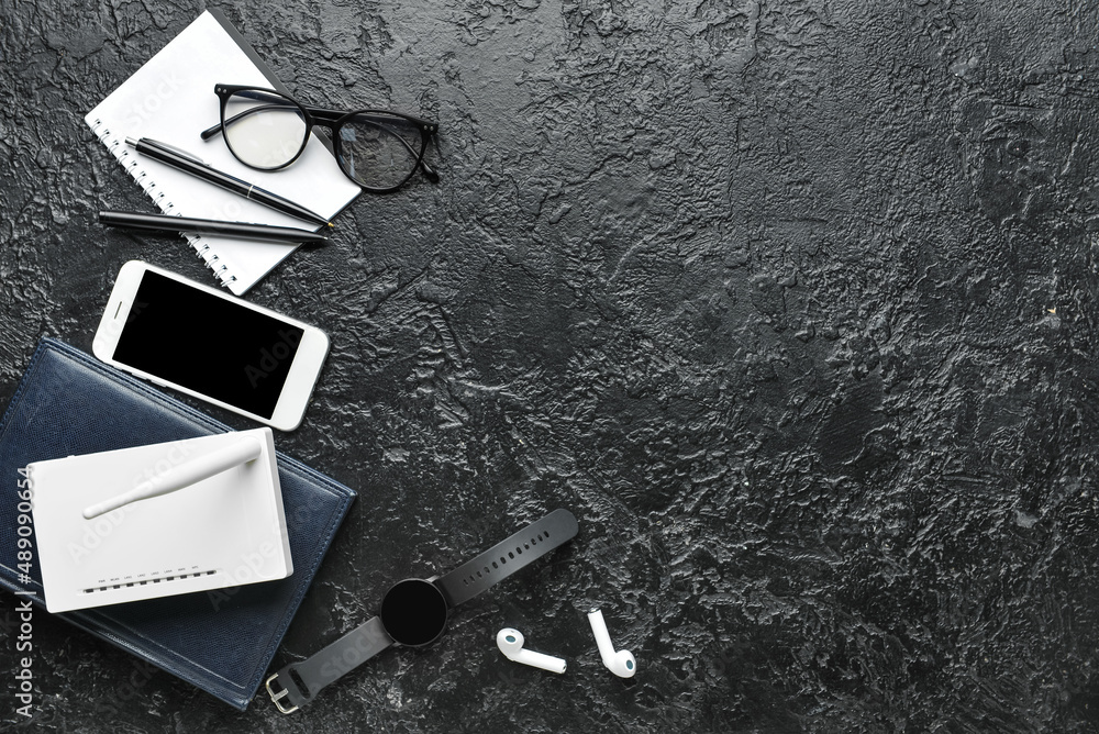 Wi-Fi router, smartphone and stationery on dark background