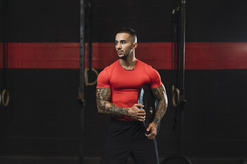 Wall Mural - Closeup shot of an athlete in the gym in a red workout shirt