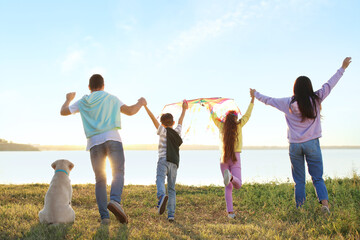 Poster - Happy family with kite and cute dog near river