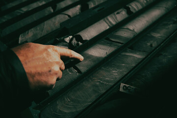 Geological gold core samples with team of mining workers measuring drilled rock top view. Selective focus 