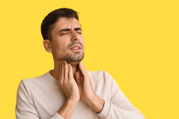 Sticker - Ill young man with sore throat on yellow background