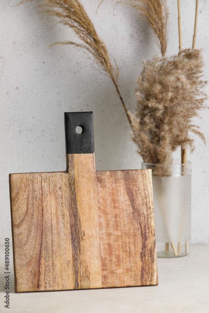 Wooden cutting board on light background