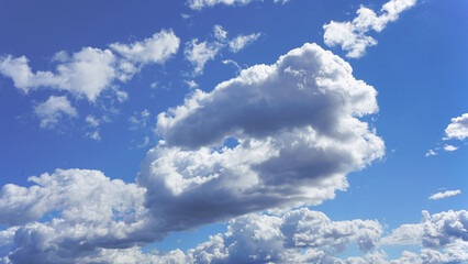 Wall Mural - billowing white clouds and blue sky suitable for background or substitution