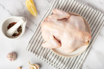 raw chicken on a white table with spices and garlic