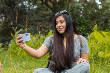 Una joven atractiva responde una videollamada al aire libre, una chica inteligente se comunica con entusiasmo en una conferencia en línea sentada en un balcón, una dama caucásica emocional hablando ,