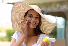 Better Safe Than Sorry. An Attractive Young Woman Applying Sunscreen To Her Face.