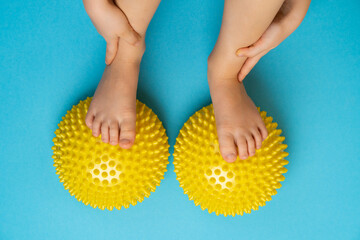 children's feet with a yellow balancer on a light blue background, treatment and prevention of flat feet, valgus deformity of the foot