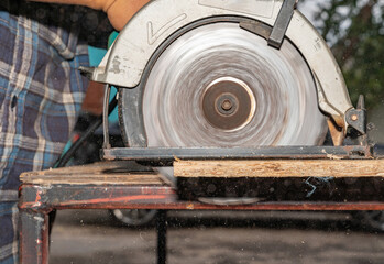 Carpenter use Circular Saw to cut wooden board.