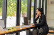 © ArLawKa - Asian businesswoman working in a coffee shop with laptop concept of people and lifestyle Technology and business theme Career Theme and Coffee Shop