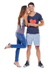 He had my heart at hello. Full-length studio shot of a young woman kissing her boyfriend who is holding a heart.