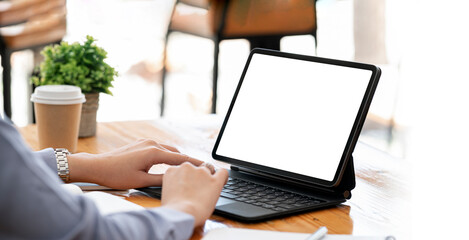 woman using digital tablet at office, mockup blank screen for product display or graphic design.