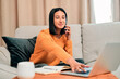 © Nicholas F/peopleimages.com - Lifes short, spend it productively. Shot of a young woman using a laptop and smartphone while working on the sofa at home.