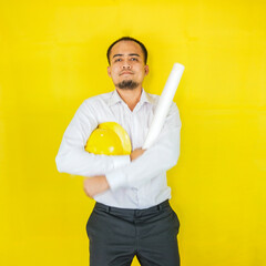 A young Asian civil engineer in a hard hat is standing on a yellow background. Act like a builder and real estate engineer.