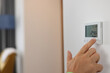 © megaflopp - Hand sets a programmable thermostat for heating and cooling