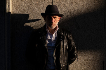 Portrait of adult man in hat and suit against wall on street. Madrid, Spain