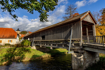 roofed wooden bridge over the river ilm in buchfart, thuringia, germany.
