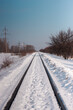 © Norgle - Railway going to the perspective. Powerlines and trees nearby. Snowy winter landscape