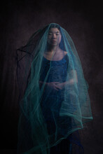 Fine Art Studio Portrait Of Asian Woman In Blue Dress Covered By Thin Veil