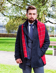 Sticker - A man in a business suit and coat poses on a spring walk
