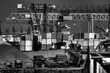 Ein Containerhafen für Binnenschiffe mit Containern, Müllbehältern und Verladekränen in Schwarz-weis