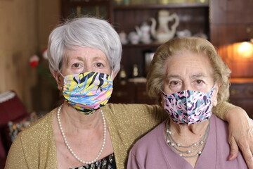 Senior female friends wearing colorful protective face masks in the 