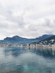 Wall Mural - Vertical of Port de Soller, Mallorca, Balearic Islands, Spain against mountains on a gloomy day