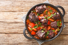 Traditional Spanish Dish Slow Cooked Oxtail In Red Wine Sauce With Rabo De Toro Closeup On A Pot On The Wooden Table. Horizontal Top View From Above