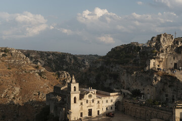 Wall Mural - Aerial view of an old gothic castle surrounded by rocky mountains under the cloudy sky