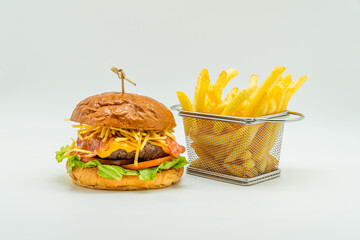 Poster - Delicious burger next to french fries in a basket isolated on white background