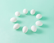 Minimal Isometric Composition With White Eggs Lined Up In A Circle On Pastel Olive Green Background With Copy Space.