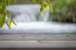 Wooden table against the blurry background with a flowing river with space for text