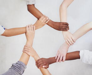 Poster - Connected as one. Shot of a group of hands holding on to each other.