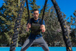 Man training with battle ropes and military vest. Training Day. Personal training