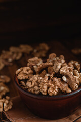 Wall Mural - Walnuts close up in a brown bowl on a dark wooden background. Organic food concept.