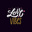 © Oktyabr - Romantic hand drawn lettering with the phrase love vibes in bright expressive style. Suitable for stickers, prints, apparel, and cute love themed designs.