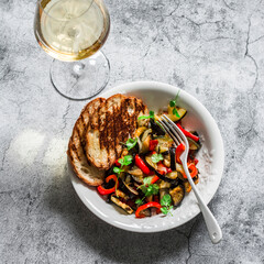 Baked ratatouille, grilled bread and glass of wine - delicious vegetarian appetizers, lunch, snack on a grey background, top view