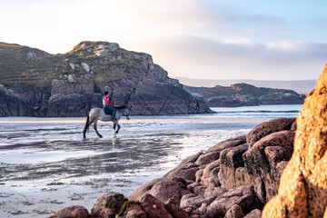 Wall Mural - Horse riding at Cloughglass bay and beach by Burtonport in County Donegal - Ireland