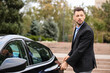 © Pixel-Shot - Handsome businessman opening car door on city street