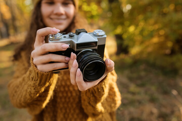 Wall Mural - Female photographer with photo camera in autumn forest