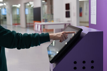 Close-up of a woman using a touch screen information booth.