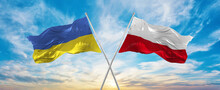 Crossed National Flags Of Ukraine And Poland Flag Waving In Wind At Cloudy Sky. Symbolizing Relationship, Dialog, Travelling Between Two Countries. Copy Space