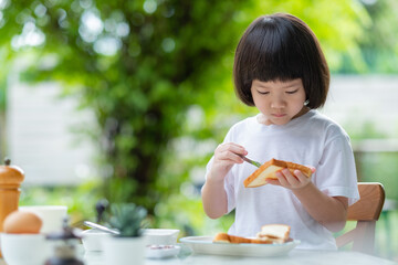 Wall Mural - Little girl have breakfast, happy time