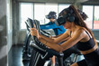 © CandyRetriever  - Healthy athletic man and woman wearing VR glasses workout exercise on cycling machine in virtual reality cyberspace at fitness gym. Metaverse digital entertainment technology and sport concept