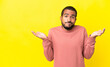 © luismolinero - Young latin man isolated on yellow background having doubts while raising hands