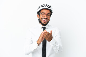 Wall Mural - Young business latin man holding a bike helmet isolated on white background applauding after presentation in a conference