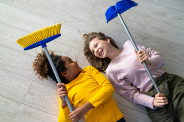 Wall Mural - Happy multiethnic teenage children are smiling while do household with mother at home.